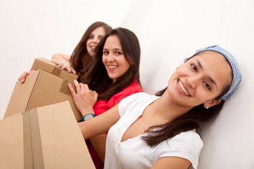Professional movers carrying furniture through a Petersham property